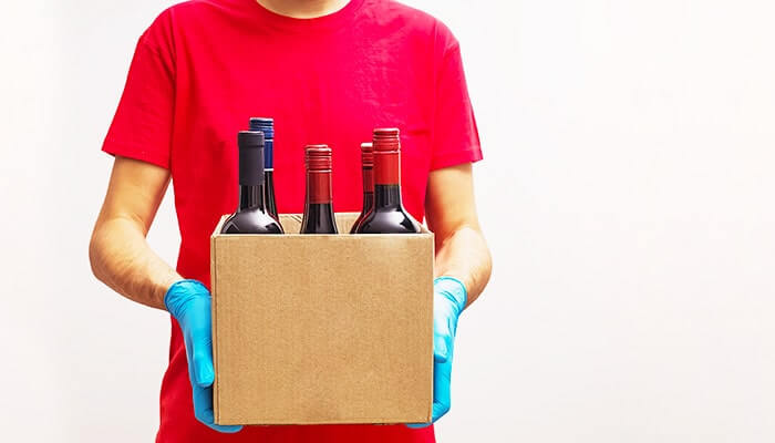 staff holding a box of wine